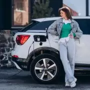 mulher abastecendo um carro híbrido