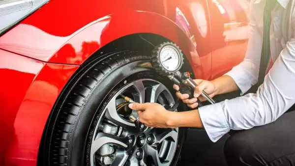 Quantas libras devo colocar nos pneus: homem calibrando pneus