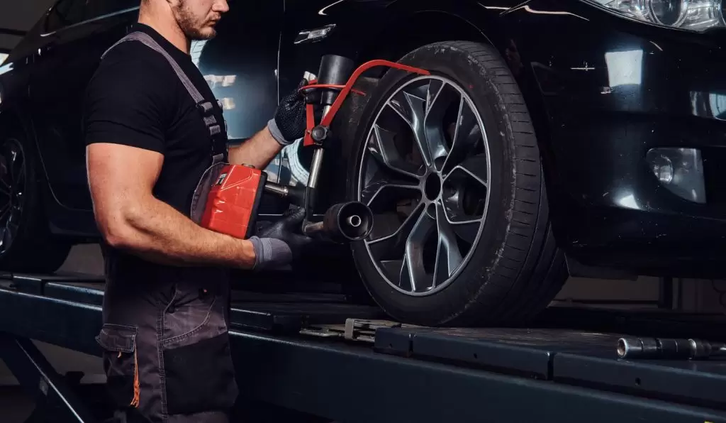 comprar pneu com desconto: profissional ajustando pneu