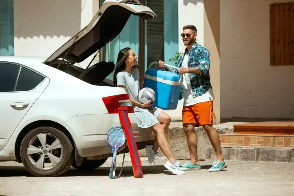 como economizar combustível: casal indo viajar de carro