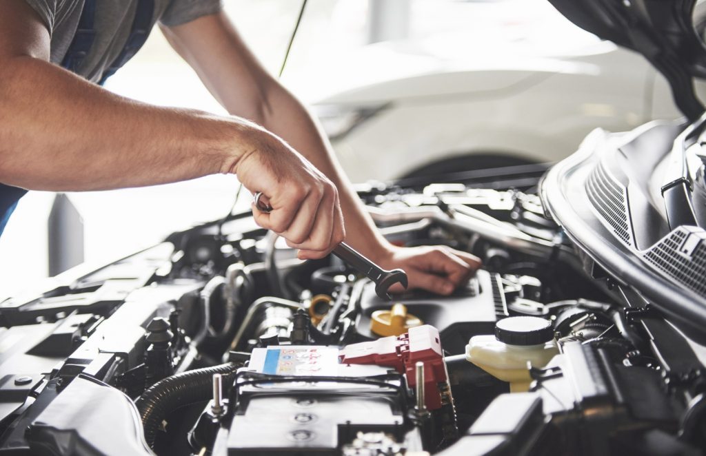 quando trocar a correia dentada: mecânico revisando motor de carro