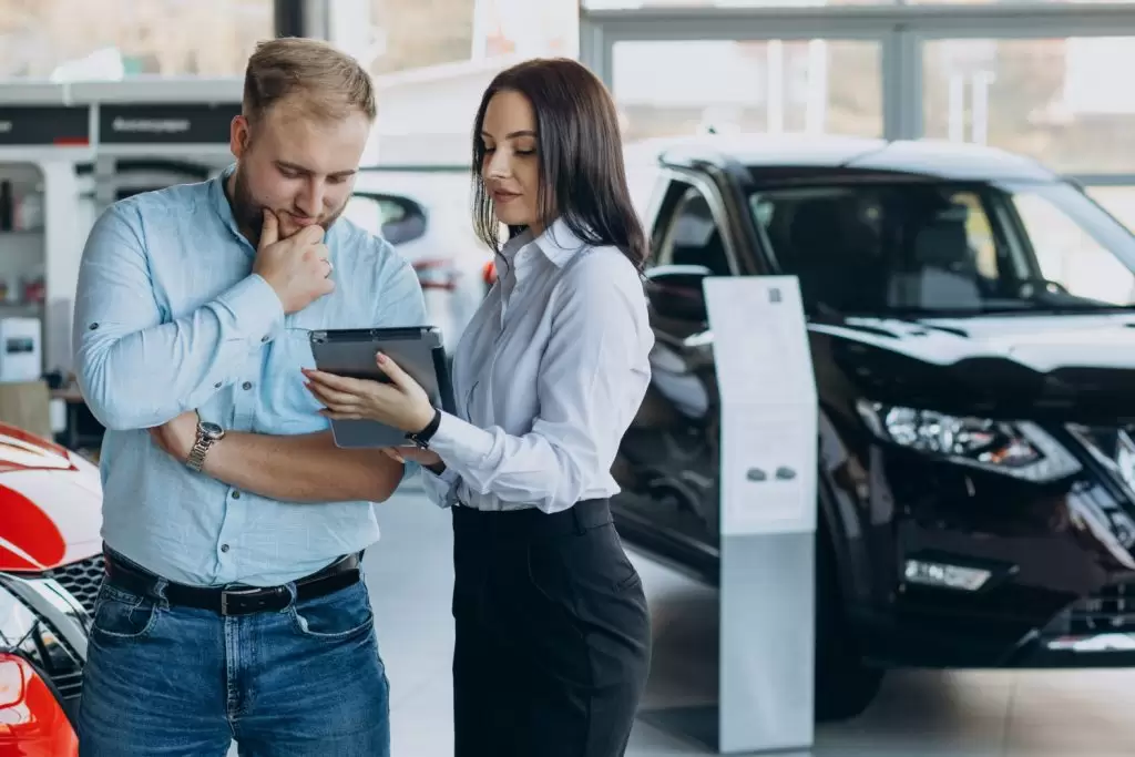 vendedor e cliente analisando taxas de veículos