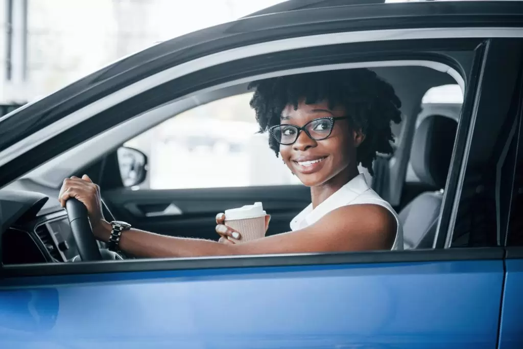 financiar carros usados: mulher bonita dentro de carro azul