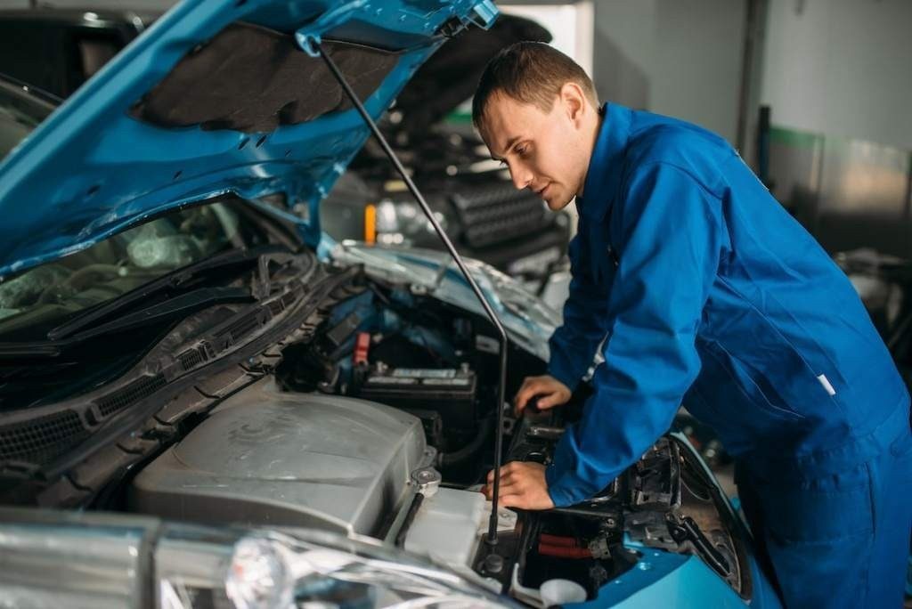 mecânico analisando motor do carro
