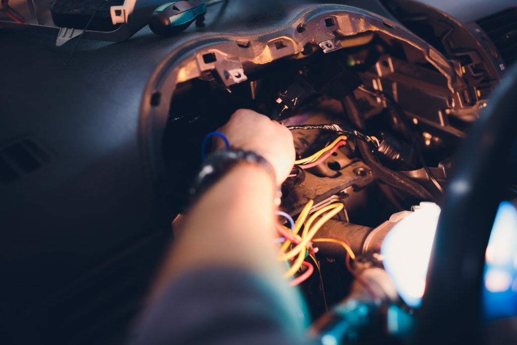  curso de elétrica automotiva: profissional trabalhando na parte elétrica de veículo