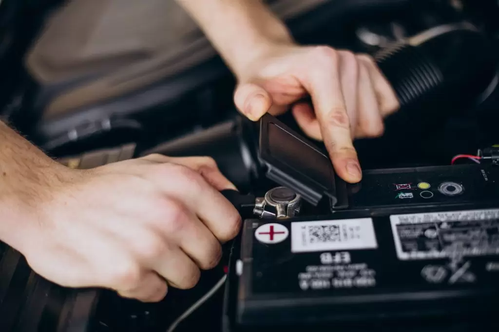 Modelo de bateria para carro: mecânico trocando a bateria