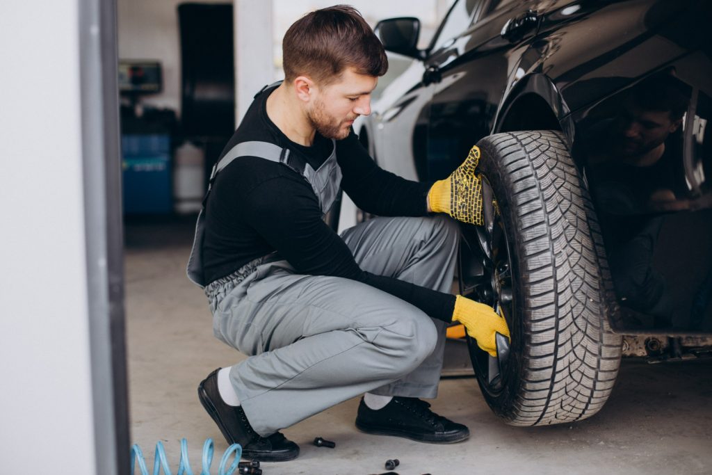 quanto custa alinhamento e balanceamento: profissional alinhando carro