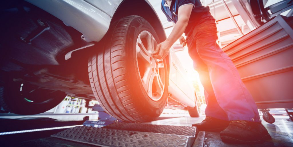 quanto custa alinhamento e balanceamento: profissional alinhando carro