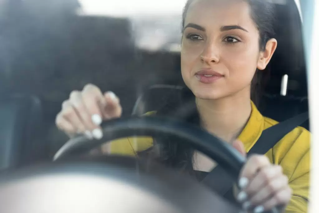 valor da multa por dirigir com celular: mulher ao volante