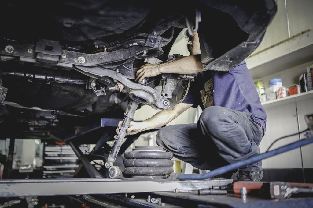 mecânico ajustando suspensão do carro